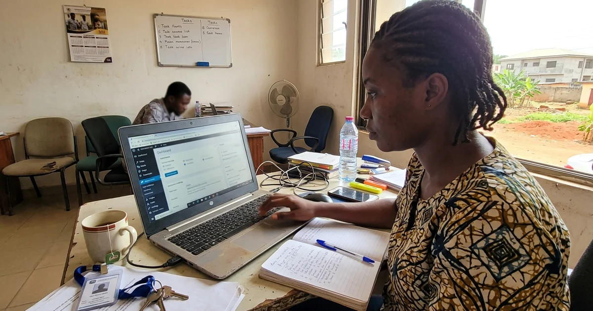 Agency staff member updating a client website on a laptop in a Kumasi office