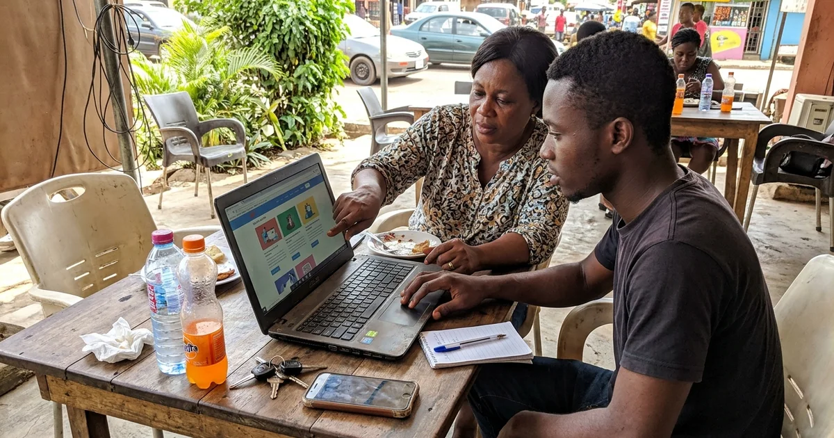 Business owner and designer reviewing a website draft on a laptop at a Kumasi cafe