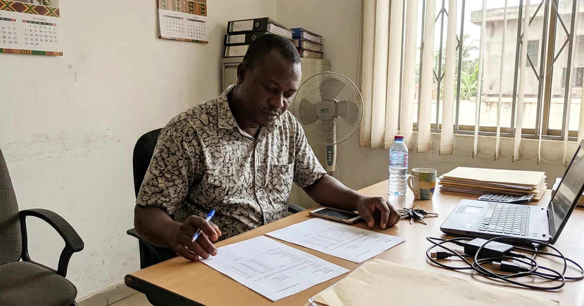 Business owner comparing two printed SEO quotes at a desk in Accra