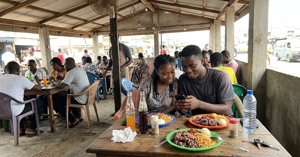 Young couple scrolling short videos on a phone at an Accra food spot
