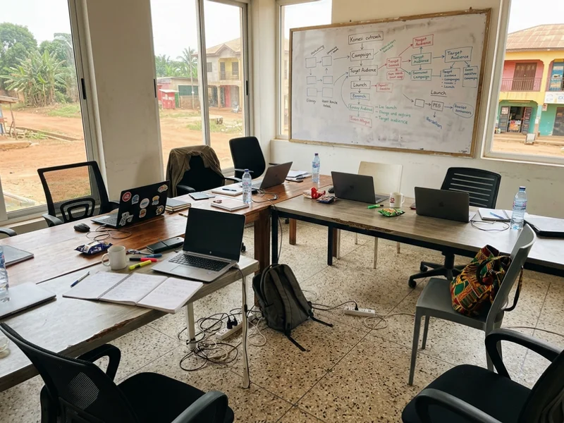 Whizzy Digital workspace in Kumasi with laptops and a planning whiteboard