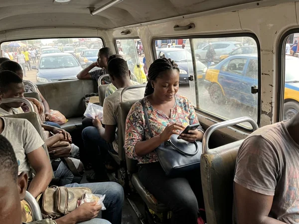 Commuter in Accra tapping a sponsored post on her phone