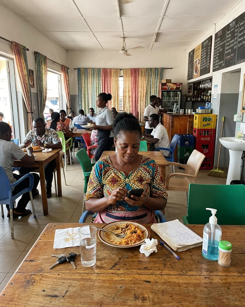 Accra restaurant owner checking her new mobile website on her phone